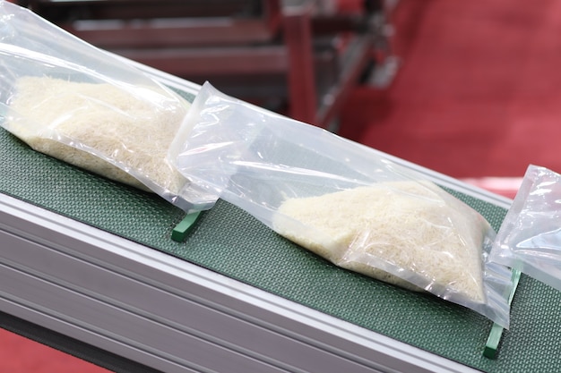 Rice packing in plastic bag on conveyor line ; close up