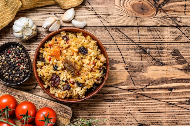 Rice pilaf with lamb meat and vegetables in a pan