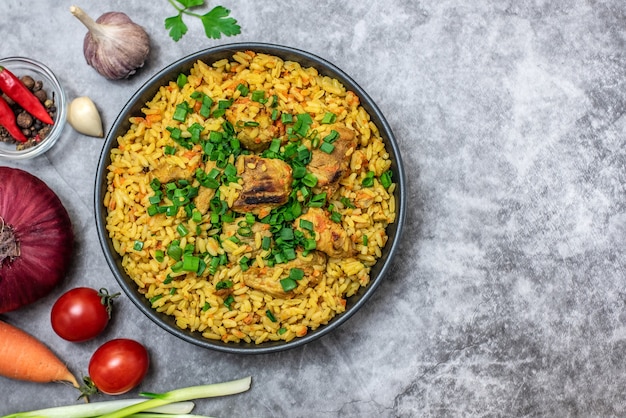 Rice pilaf with meat carrot and onion on grey background. Top view.