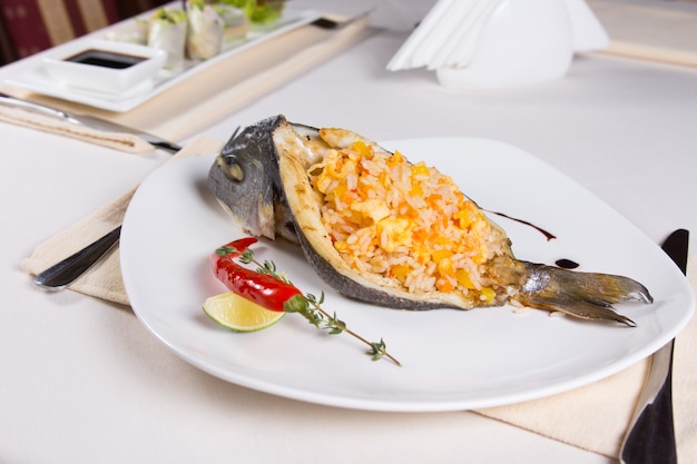 Rice Stuffed Fish Dish on Plate at Restaurant Place Setting