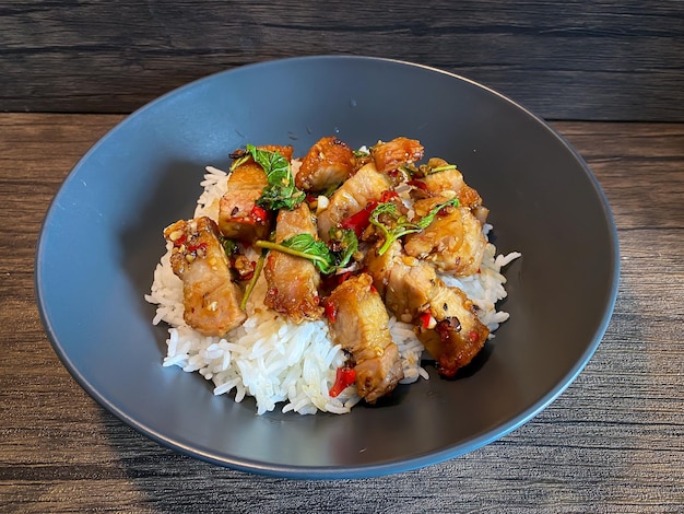 Rice topped with crispy pork belly with Thai basil