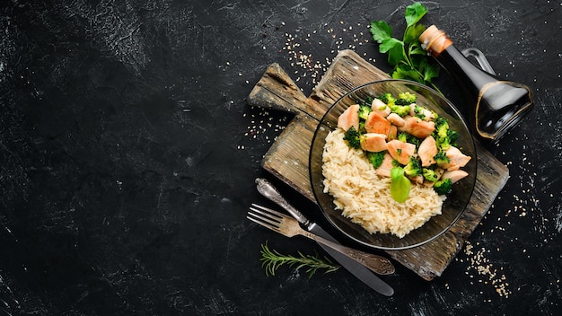 Rice with chicken fillet and vegetables Top view On a black background Free copy space