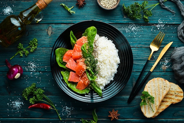 Rice with red fish green beans and spinach in a black plate Diet Top view Free space for text