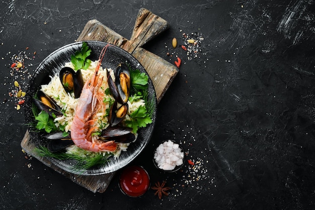 Rice with seafood Risotto with shrimp and mussels In a black plate Top view Free copy space