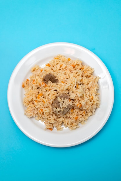 Rice with vegetables and meat on white plate