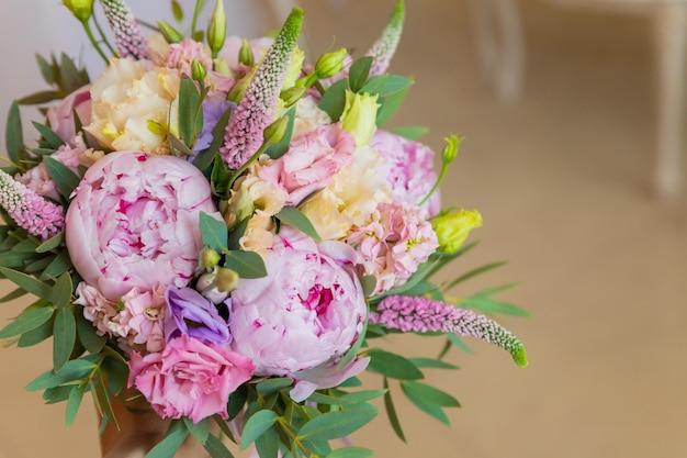 Rich bunch of pink peonies and lilac eustoma roses flowers green leaf Fresh spring bouquet Holodays giftArrangement of Beautiful blossoming flowerswedding bouquetcopy space