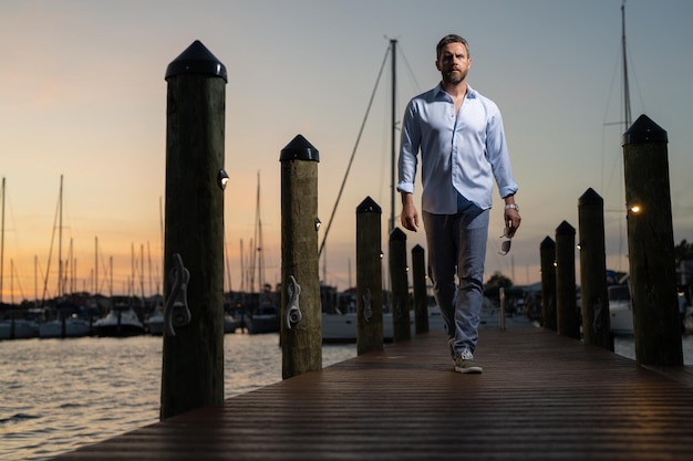 Photo rich summer business man near the yacht portrait of fashion male model outdoor rich male posing near