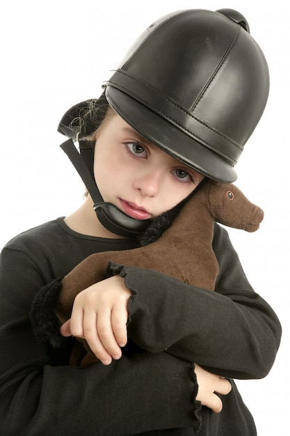 Riding cap little girl hug toy horse