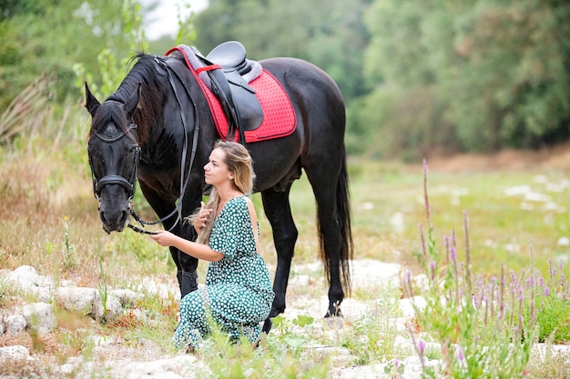 Riding girl are walking with her black horse