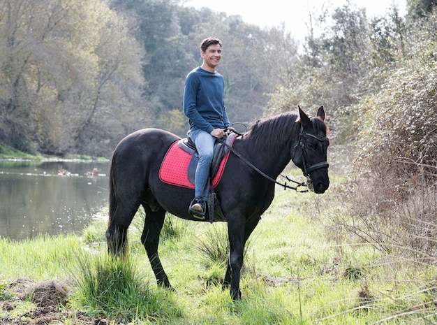 Riding man are training her black horse