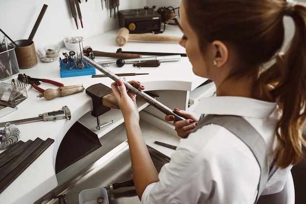 Right size portrait of female jewelry designer measuring a ring with metal ring sizer