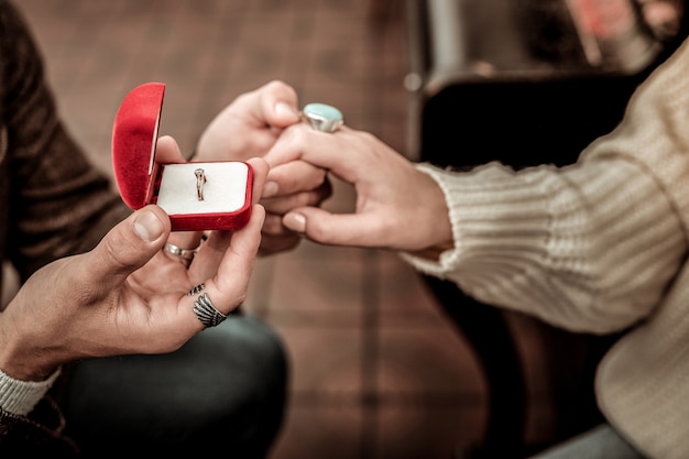 Photo ring with a diamond. man is bringing a ring to his partner while making a proposal