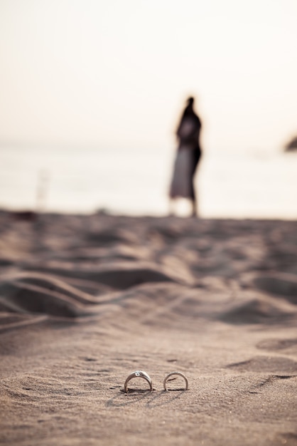 rings on beach with bride and groom on background