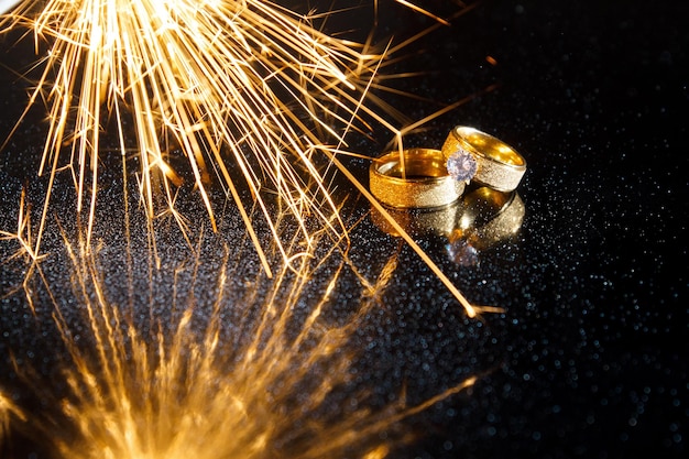 Rings on a dark background. Wedding rings. Jewelry. Sparklers