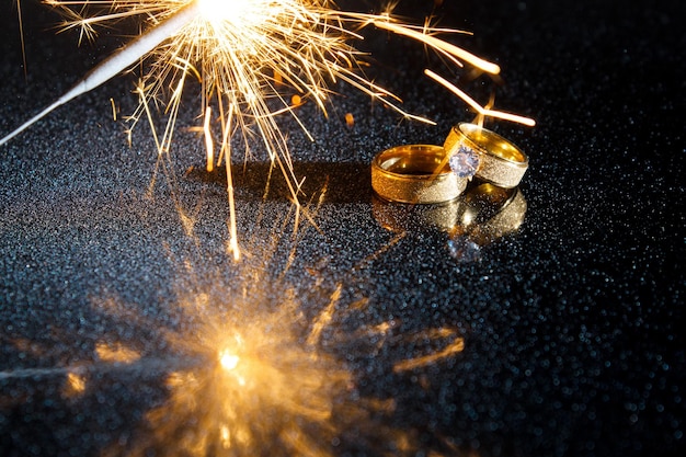 Rings on a dark background. Wedding rings. Jewelry. Sparklers