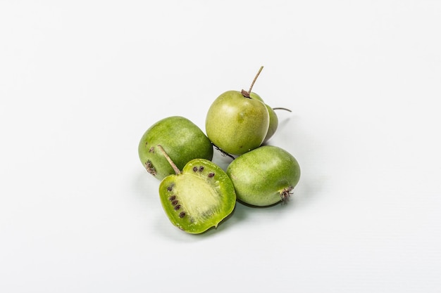 Ripe Actinidia arguta or kiwi isolated on white background. Branches of fresh fruits with green leaves, mockup, template