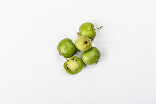 Ripe Actinidia arguta or kiwi isolated on white background. Branches of fresh fruits with green leaves, mockup, template