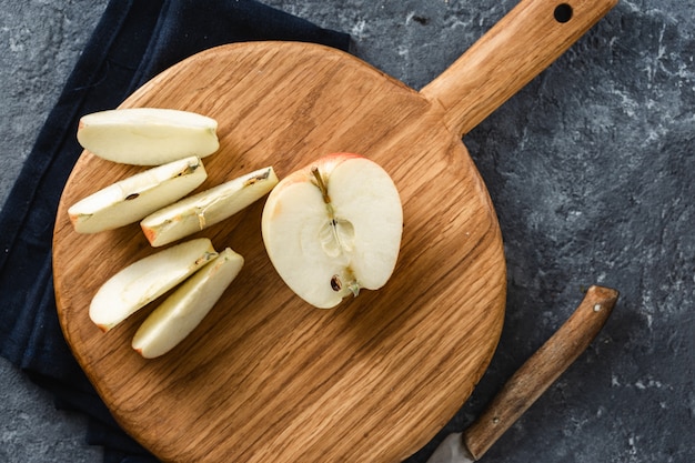 Ripe apple slices wooden cutting board top view