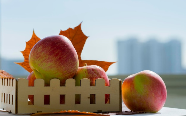 Ripe apples in a wooden box. Autumn leaves