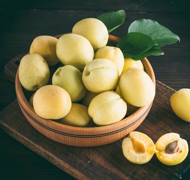 Ripe apricot varieties of pineapple in a wooden plate