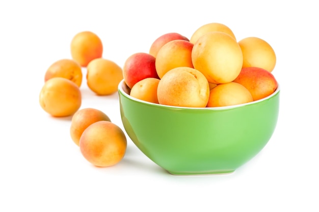 Ripe apricots in a ceramic bowl isolated on a white background