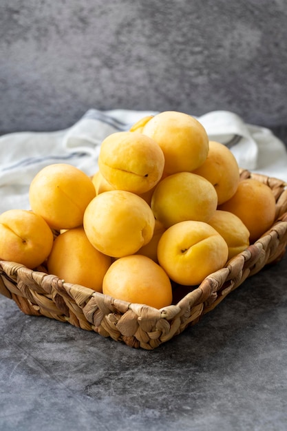 Ripe apricots on a dark background Fresh and juicy apricots in the basket Organic food close up