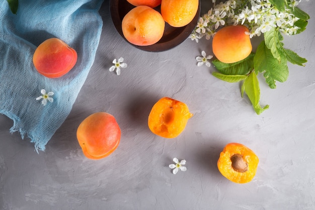 Ripe apricots and flowers on the table.