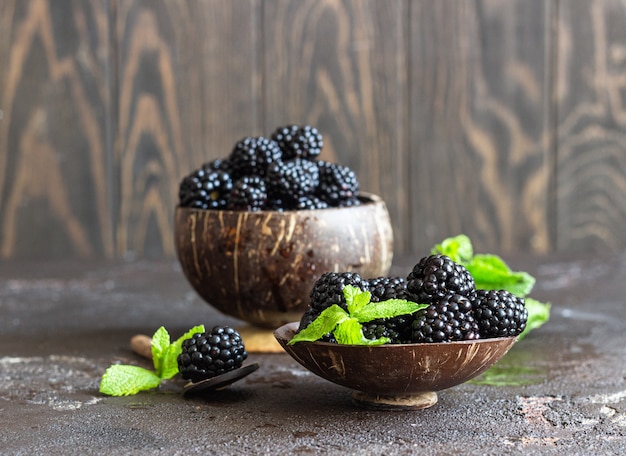 Ripe blackberries with mint on a dark brown stone surface