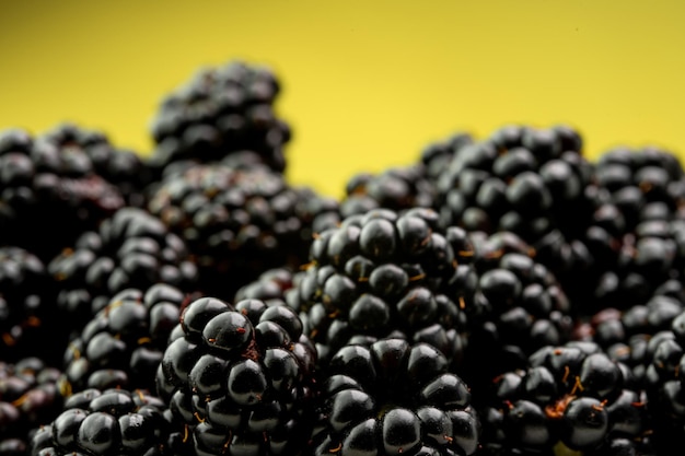 Ripe blackberries on a yellow background