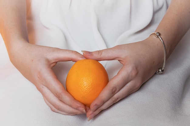 Ripe bright orange in tender female hands