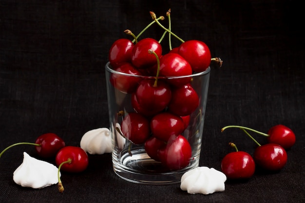 Ripe cherry in a glass on a black background