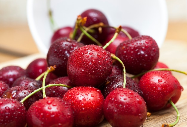 Ripe cherry maroon covered with water drops. Berries are together after the harvest.