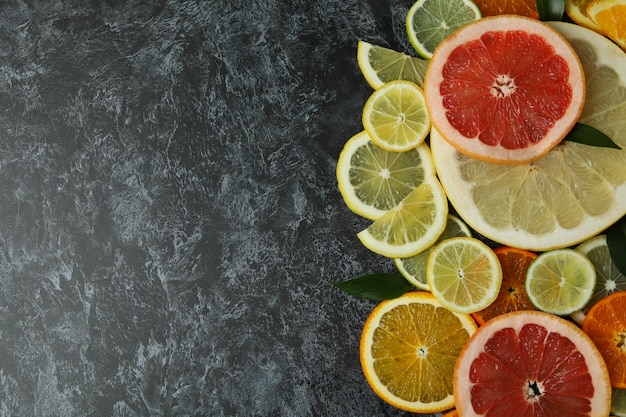 Ripe citrus slices on black smoky table