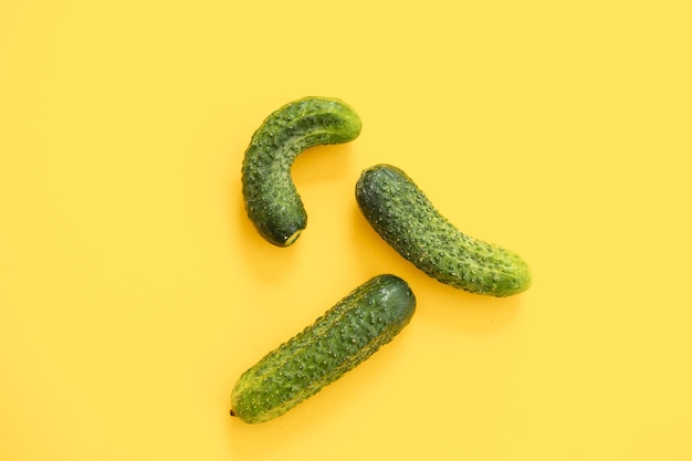 Ripe cucumber on yellow background Flat lay