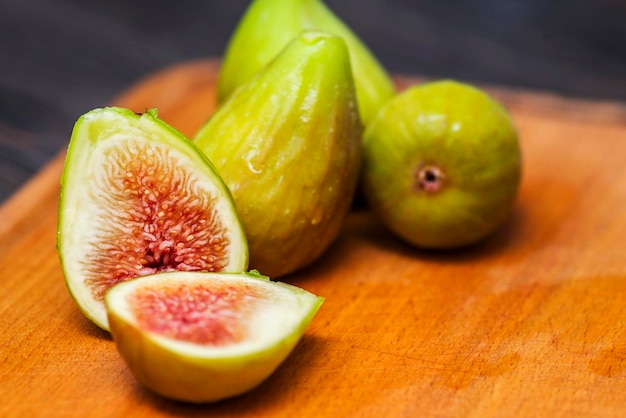 Ripe fresh figs on a cutting kitchen board on a rustic wooden table Ripe tasty figs