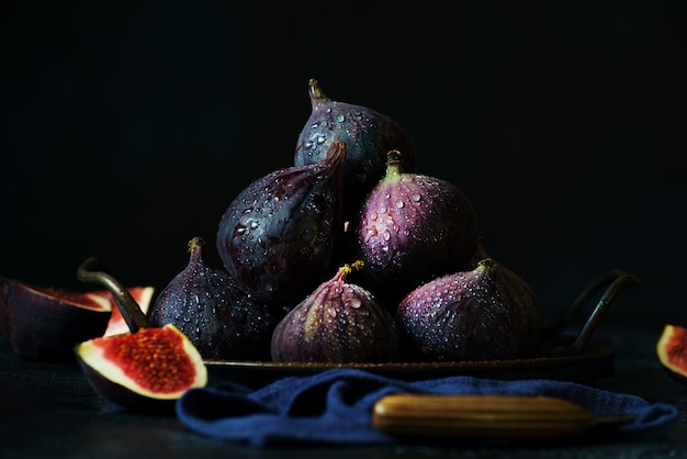 Ripe fresh figs in a tin cup on a dark background, horizontal orientation, southern fruit