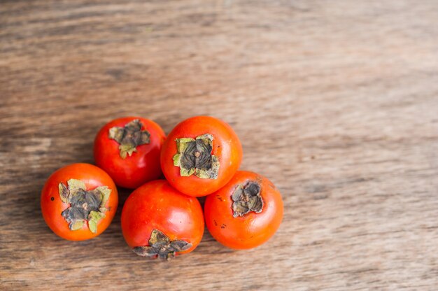 Ripe fresh persimmon on wood board