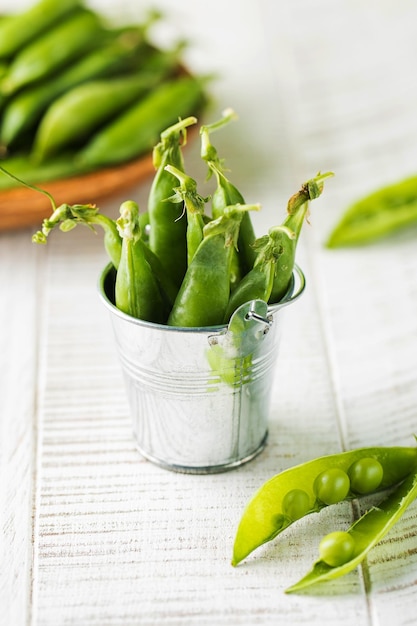 Ripe fresh young green peas in a metal bucket Copy space