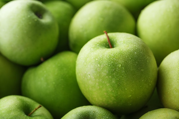 Ripe fruit of a green apple in close-up with dew drops.