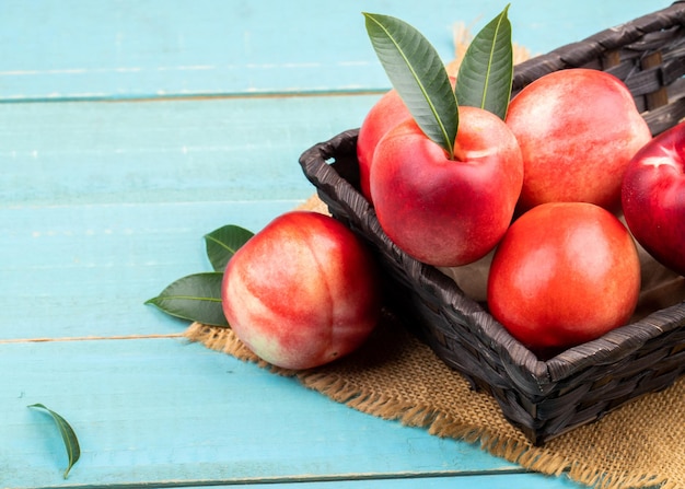 Ripe garden apple fruits in basket on wooden table