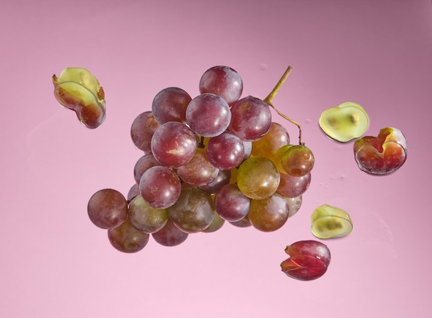 Ripe grape lie on glass Sliced grapes on pink background Idea beauty nature and proper nutrition