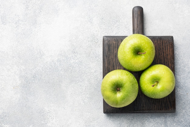 Ripe green apples on a gray concrete background