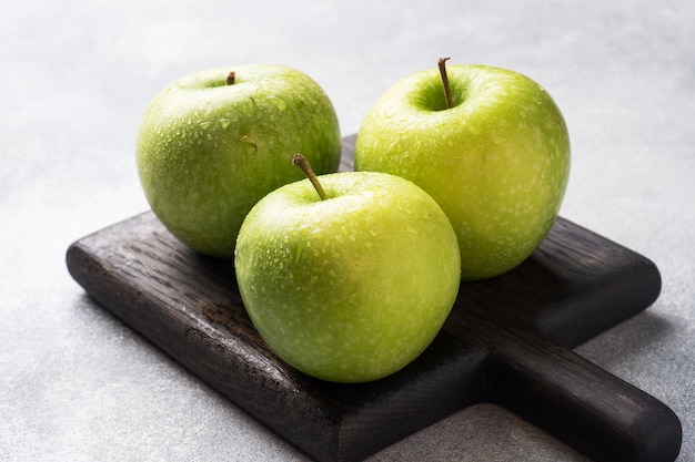 Ripe green apples on a gray concrete