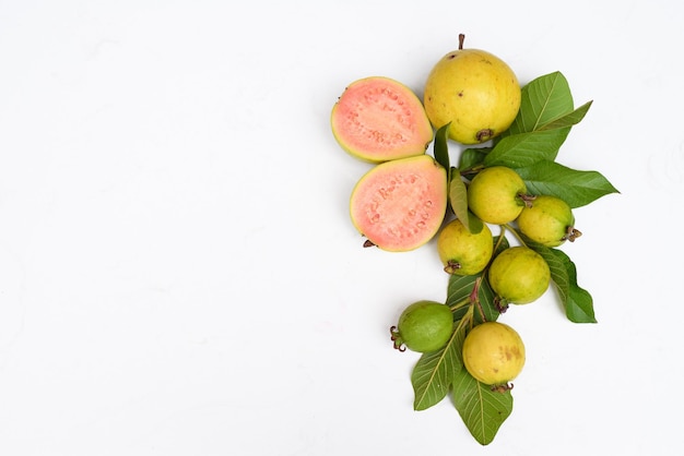 Ripe guava fruit with leaves on white background with copy space