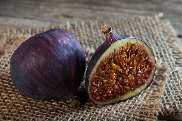 Ripe half figs of an old wooden table and burlap