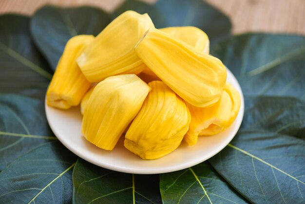 Ripe jackfruit peeled tropical fruit fresh from jackfruit tree Jackfruit on white plate and green leaf background