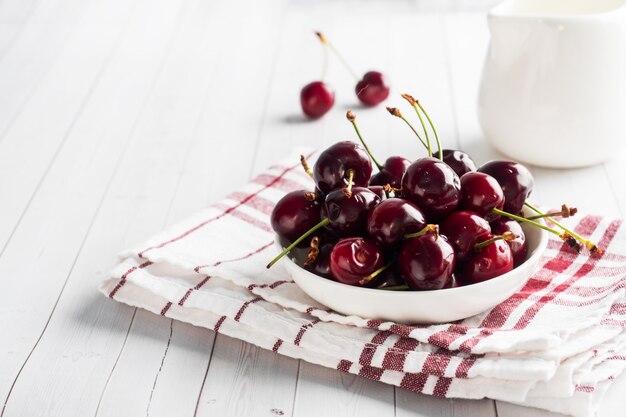 Ripe juicy cherry berries on a plate. White background. .