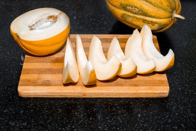 Ripe juicy melon cut into slices on a wooden board Delicious healthy food