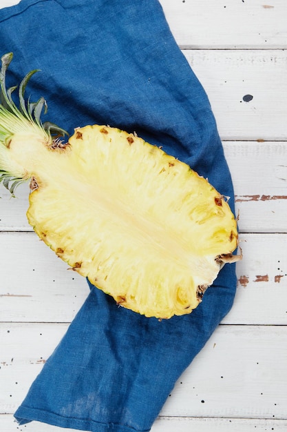 Ripe and juicy pineapple on a white wooden table pineapple half slices closeup