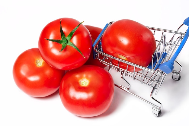 Ripe juicy red tomatoes with a grocery cart Autumn harvest Shopping cart with food products